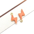 Macro shot of orange enamel lightning bolt charms with gold plating for jewelry making - Gold Orange