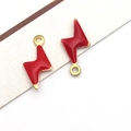Macro shot of red enamel lightning bolt pendants with gold-plated metal base and jump rings - Gold Red