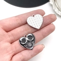 Macro view of gothic heart charms featuring skull relief and houndstooth texture - Heart Skull Style (19386)