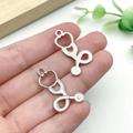 Ciondoli a forma di stetoscopio in lega d'argento per gioielli fai-da-te mostrati in mano - Design Stetoscopio Piccolo Argento Bianco (23227)