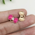 Pink enamel bow pendant with gold finish and zircon center shown on fingertips - Rose Red Rhinestone Bowknot