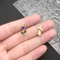 Rose flower alloy pendants in blue enamel and gold finish held for scale - Blue Enamel Rose (11966)