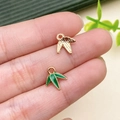 Macro view of gold bamboo leaf charms for DIY jewelry held between fingers - Panda Bamboo Leaf Charm (21664)