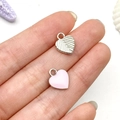 Pink enamel and textured silver metal heart charms held in hand for scale - Pink Heart Style (21897)