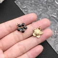 DIY flower charm pendants in black enamel and embossed gold finish held in hand - Black Enamel Cherry Blossom (10957)