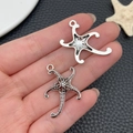 Vue détaillée du pendentif étoile de mer argentée sur fond en cuir noir texturé - Grande Étoile de Mer (22905)