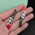 Detail of acrylic Halloween knife charms with skull print and red splatter held in hand - Black Acrylic Skull With Blood Knife (19277)