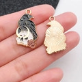 Pendentif gothique corbeau et crâne avec émail noir et rose tenu dans la main - Corbeau Crâne (16648)