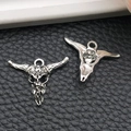 Detailed macro view of vintage silver bull skull pendants showing front and back textures - Sun Pattern Bull Head Style (16968)