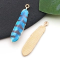 Vue macro détaillée du pendentif plume avec recto bleu rayé et verso doré avec texture maille - Plume Texture Rayée Bleu Et Noir