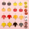 Detailed close-up of enamel pumpkin and maple leaf pendants for autumn DIY jewelry making - Enamel Maple Leaf and Pumpkin Set (SN279)