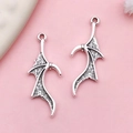 Antique silver bat wing charms in alloy metal for DIY jewelry making on pink background - Bat Wing Pendant (18641)