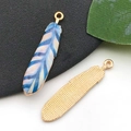 Pendentifs plumes en émail bleu et blanc avec dos en métal doré pour création de bijoux - Plume Texture Bleu Et Blanc