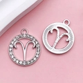 Silver Aries zodiac pendants featuring rhinestone inlay and radial textured metal finish - Aries