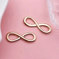 Macro shot of rose gold infinity charm pendants for DIY jewelry and earring design - Infinite Symbol