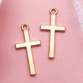 Macro shot of two rose gold cross pendants for DIY jewelry making and crafting - Cross