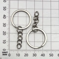 Close-up of metal key rings with short link chains on a metric measurement grid - White K 25mm Ring With Chain (13508)