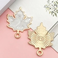 Golden maple leaf pendant charm with white enamel and sunburst textured metal back - White