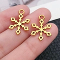 Nahaufnahme von zwei goldenen Schneeflocken-Anhängern aus Legierung zur Größendarstellung - Weihnachtsschneeflocke (20063)