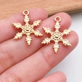 Primer plano de dos colgantes dorados de copos de nieve para joyas artesanales - Copo de Nieve de Navidad (20042)
