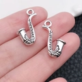 Makroaufnahme von zwei silbernen Saxophon-Anhängern aus Zinklegierung für Schmuck - Antiksilber Saxophon (9164)