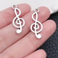 Silver treble clef metal pendants in hand for DIY jewelry making and crafts - Antique Silver Treble Clef (5619)