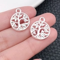 Macro view of silver tree of life pendants held in hand for jewelry making - Bright Silver Round Tree Of Life (19905)