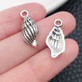 Antique silver shell charm with retro texture shown on fingertip for size - Marine Conch (11188)