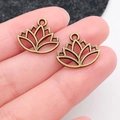 Pair of antique bronze lotus flower pendants for DIY jewelry making held in fingertips - Hollow Yoga Lotus (9049)