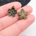 Antique bronze flower pendants in five-petal style shown for DIY jewelry crafting - Cherry Blossom (20481)
