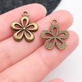 Antique bronze flower pendants for DIY jewelry making shown in hand for size context - Hollow Flower (20490)