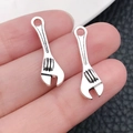 Silver alloy wrench charm pendants for DIY jewelry making in a hand-held close-up - Wrench Tool (5274) / 24x7mm