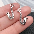 Pair of antique silver saxophone charms held on fingertips to show small scale - Antique Silver Saxophone Style (9164)