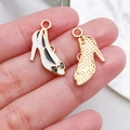 Macro view of high-heeled shoe charms with white enamel and black bow details - White Bow High Heels