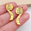 Detail of vintage gold tape measure charms for DIY jewelry making held in hand - Vintage Tape Measure (20235)