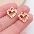 Golden hollow heart charm with caviar texture border shown on fingertip for scale - Heart Shape (19979)
