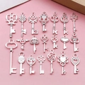 Set of 21 silver heart wing key charms for DIY necklace jewelry on a pink background - Bright Silver Keys 20 Styles Mixed (SN926)