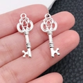 Close-up of vintage silver metal key charms with intricate hollow patterns for DIY jewelry - Bright Silver Hollow Handle Key (20976)
