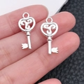 Macro detail of silver heart wing key charms showing intricate scrollwork design - Bright Silver Scroll Pattern Key (20967)