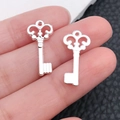 Detailed macro of vintage silver heart key pendants with intricate baroque openwork design - Bright Silver Baroque Small Key (20963)