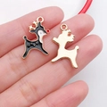 Emaillierte Rentier-Anhänger in Gold für DIY-Schmuck auf der Hand präsentiert - Weihnachtshirsch