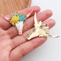 Détail d'un pendentif tête de taureau émaillé floral coloré tenu dans la main - Tête de Taureau Pointue à Fleurs en Alliage de Zinc Émail Rose (20301)
