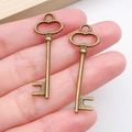 Vintage bronze key pendants for DIY jewelry making shown in hand for scale - Vintage Artistic Key Style (537) / Antique Bronze