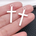 Pair of polished silver cross pendants for DIY jewelry making held in a palm - Classic Cross Style (20345)