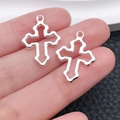 Silver hollow cross pendant pair for DIY jewelry making held in hand for scale - Wavy Hollow Cross Style (20349)