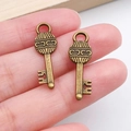 Antique bronze key pendants for DIY jewelry making shown held by fingers - Vintage Line Texture Key (20979) / Antique Bronze