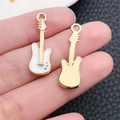Close-up of gold and white enamel guitar pendant showing front and back DIY details - White Musical Instrument Guitar (19457)