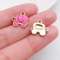 Detailed macro view of pink enamel pumpkin carriage charms with gold finish for DIY crafts - Pumpkin Carriage