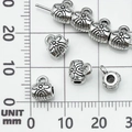 Dettaglio macro di perline distanziatrici a girasole in argento antico per gioielli DIY - Connettore Gancio Foro Piccolo Argento Antico (21091) / 8x6 Foro 3mm