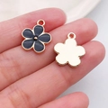 DIY black flower pendant charm with gold alloy edges and enamel finish held in hand - Black Enamel Alloy Flower (11879)